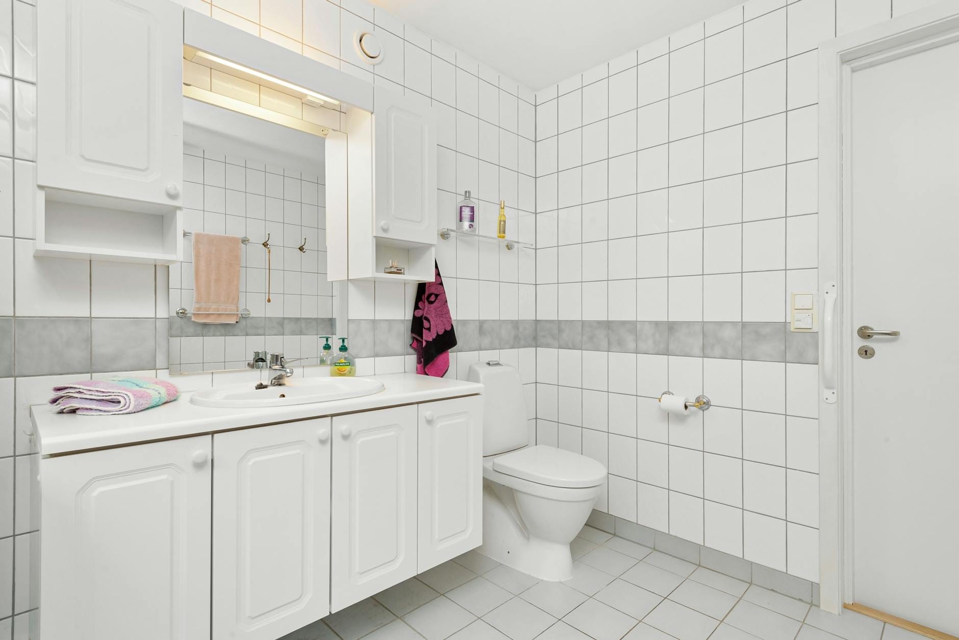 Jasna nowoczesna łazienka z białymi płytkami i minimalistyczną aranżacją