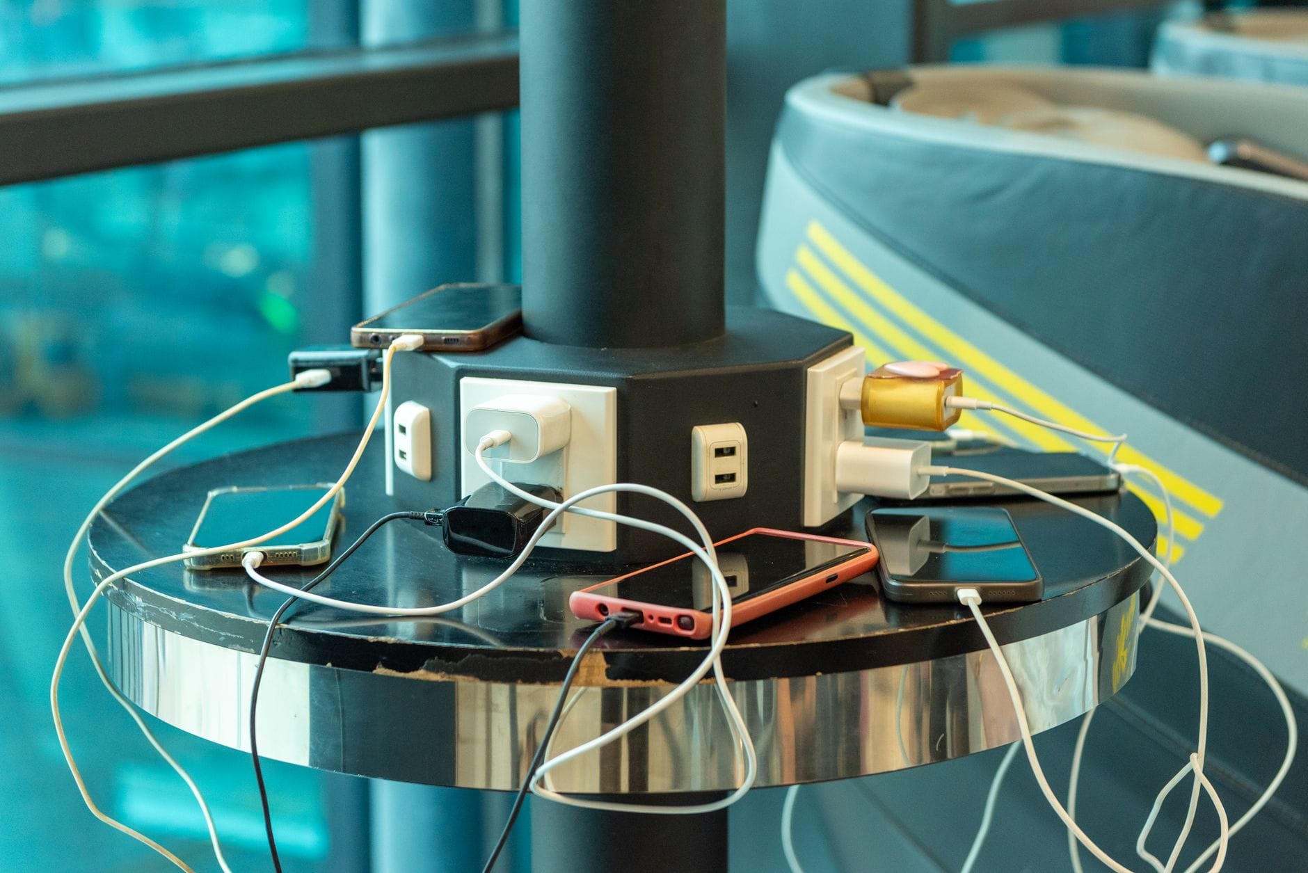 Telefony podłączone do gniazdek i USB w publicznej stacji ładowania